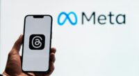 a person holding up a cell phone in front of a sign